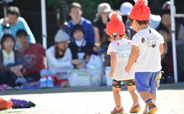 競技中の子供と応援する保護者の画像