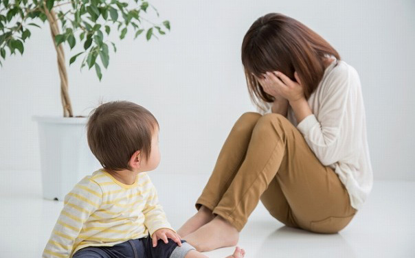 遊ぶ赤ちゃんと泣く女性