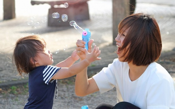 シャボン玉で遊ぶ女性と子供