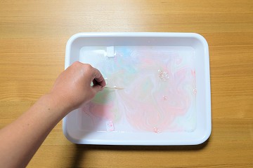 バットに用意した色が広がったら、水面をつまようじでやさしくかきまぜる